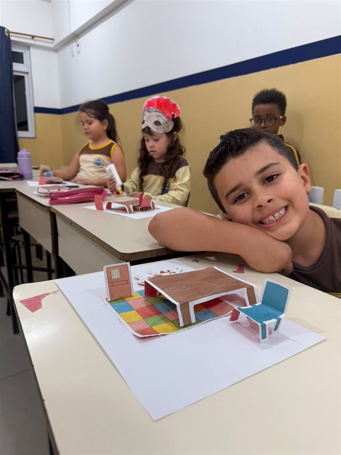 Aluno sorrindo durante atividade prática em sala